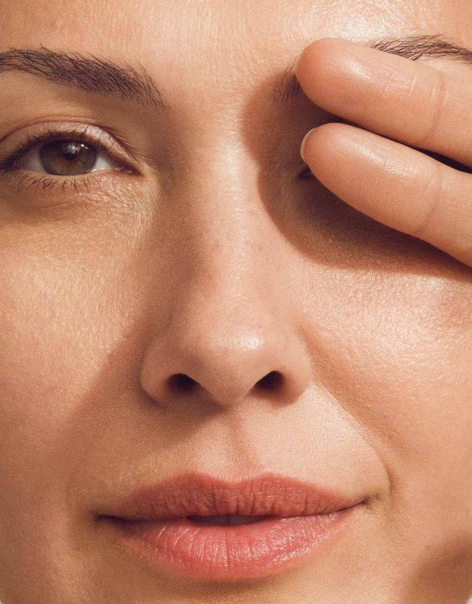 Nærbilde av et ansikt hvor en person holder hånden delvis over det ene øyet, som viser hudtekstur og øyepartiet i forbindelse med behandling for rynker og hudforbedring rundt øynene.